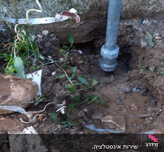 צינור מתכת מחובר לקרקע עם מים ובוץ